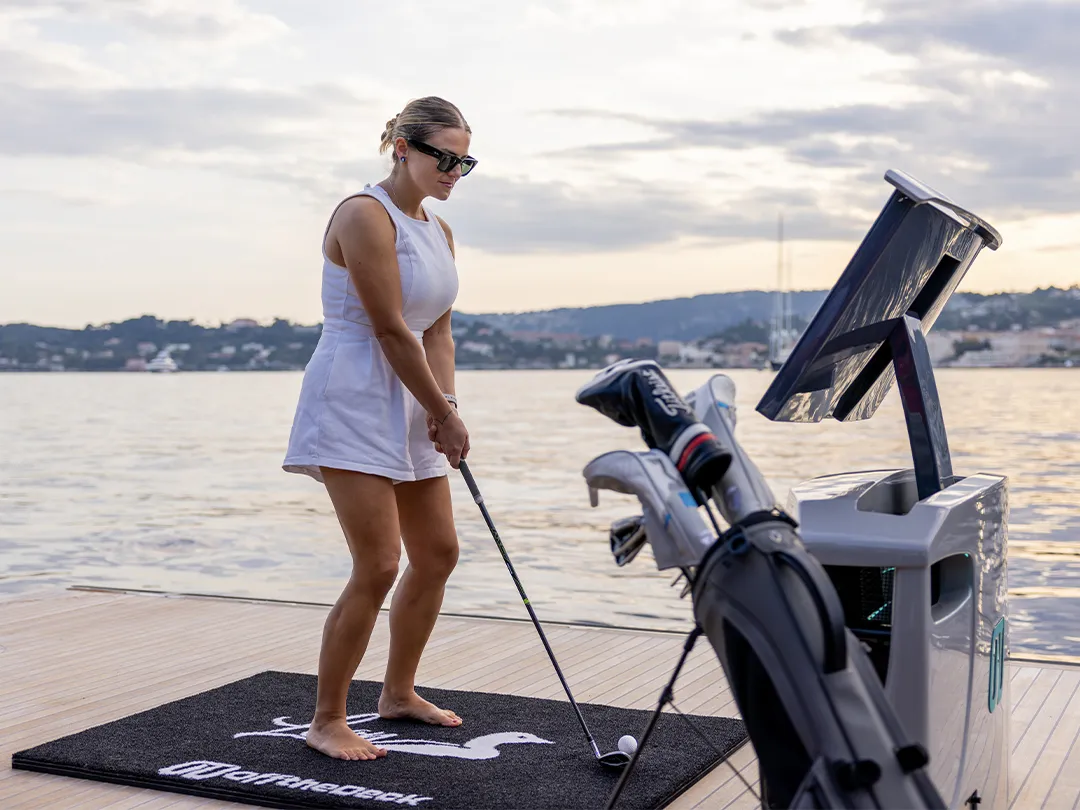 Female superyacht charter guest playing golf with Off the Deck