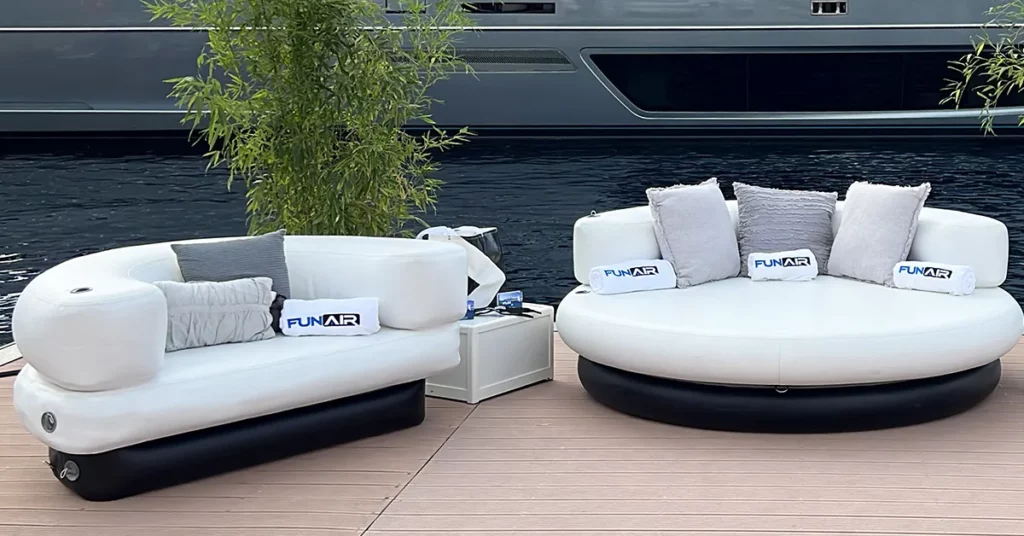 The FunAir club chaise and chairs in front of a luxury yacht